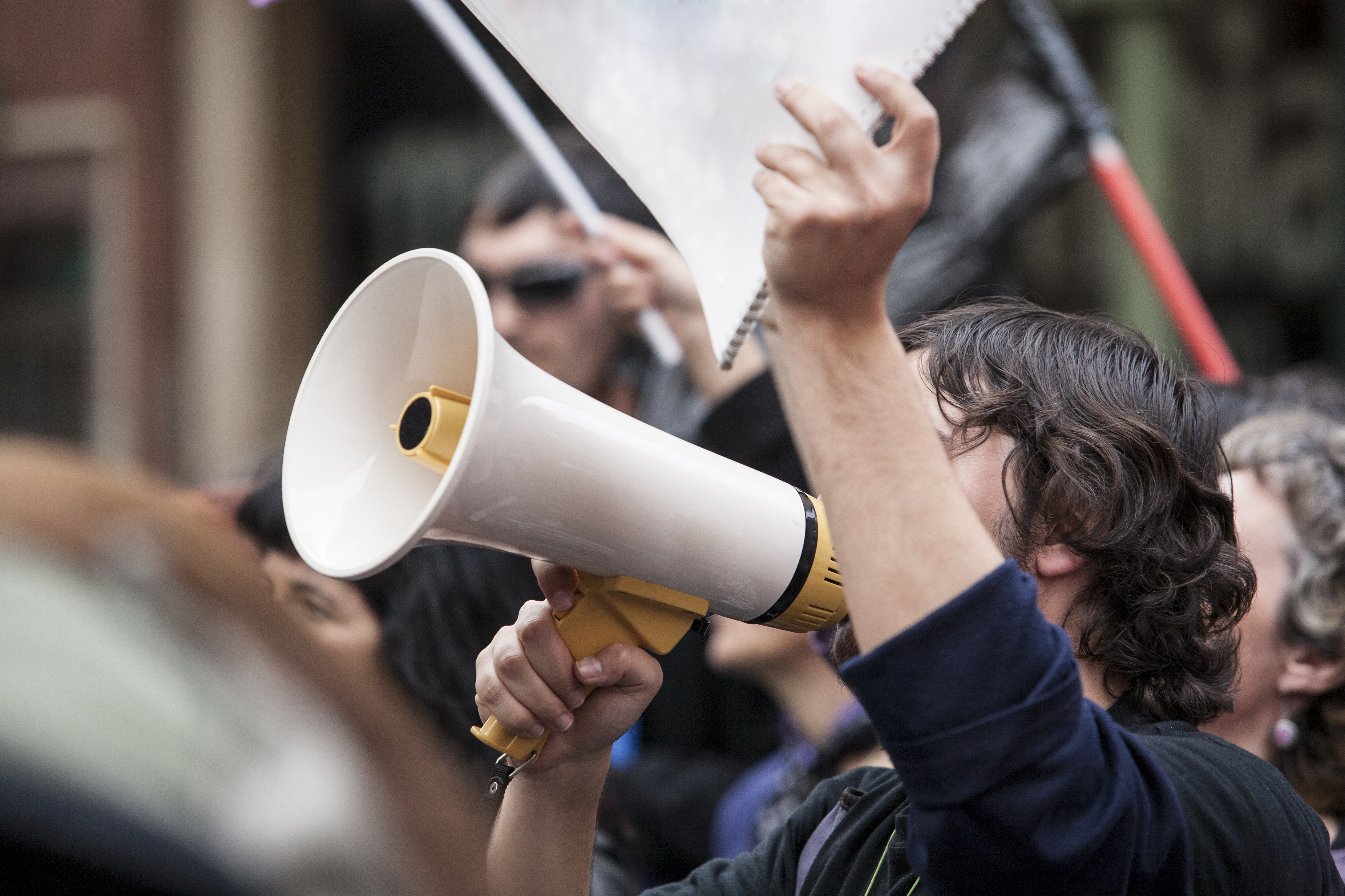 Person speaking into a megaphone at a rally.
