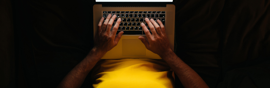 AI and academic misconduct Banner Person working on a laptop in the dark