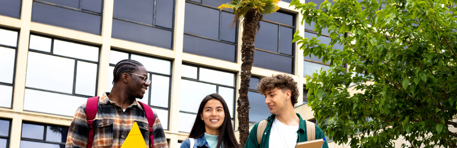Three students walking away from a university building